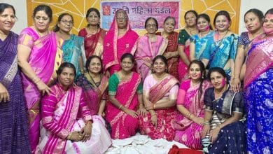 उन्नति महिला मंडल द्वारा आयोजित होली उत्सव में गुलाल और फूलों की होली खेलते हुए लोग।