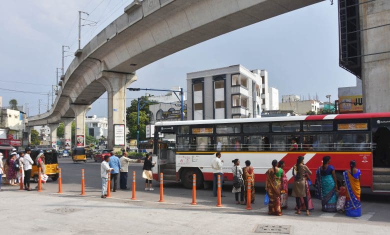 बस स्टैंड पर कड़ी धूप में बस का इंतजार करते लोग