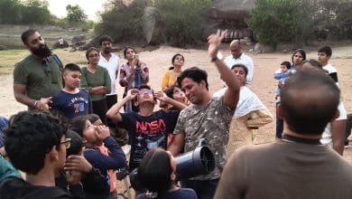 स्टारगेजिंग कैंप में टेलीस्कोप से तारों को निहारते लोग