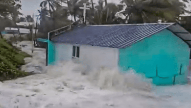 केरल में बाढ़ग्रस्त क्षेत्र में नाव से लोगों को सुरक्षित स्थान पर ले जाते हुए बचावकर्मी