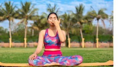 कामकाजी महिला योग करते हुए मानसिक संतुलन बनाए रख रही है