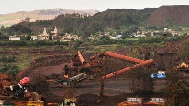 एनएमडीसी का लोगो और लौह अयस्क स्टॉक रिपोर्ट के साथ बीएसई ट्रेडिंग डिस्प्ले।