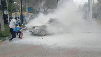 पेट्रोल पंप पर जलती कार को बुझाते कर्मचारी