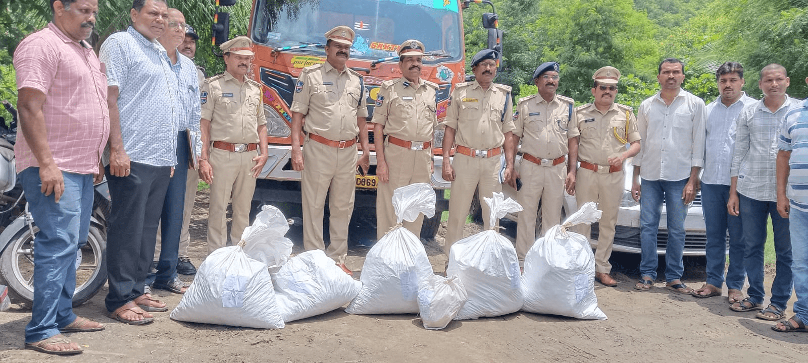 पुलिस अधिकारियों द्वारा जब्त किए गए गांजा और गिरफ्तार आरोपी