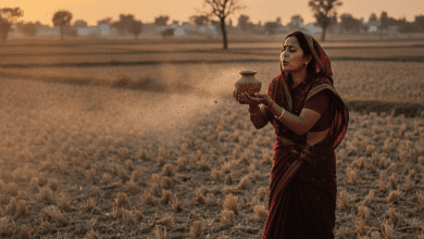 खेत के किनारे खड़ी महिला, राख़ को हवा में उड़ाते हुए