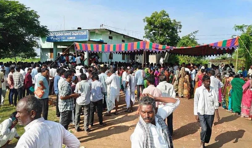 निर्मल जिले के सोयाबीन खरीद केंद्र पर भगदड़ के बाद घायल महिलाओं को मदद करते लोग