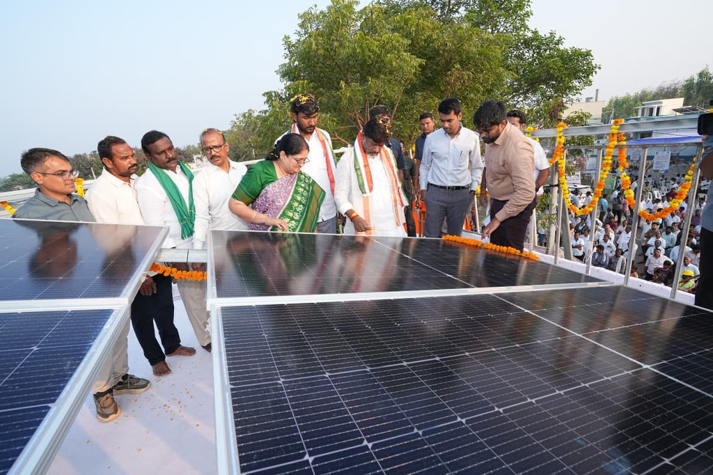 मॉडल सोलर ग्राम में सौर पैनल लगाते हुए ग्रामीण