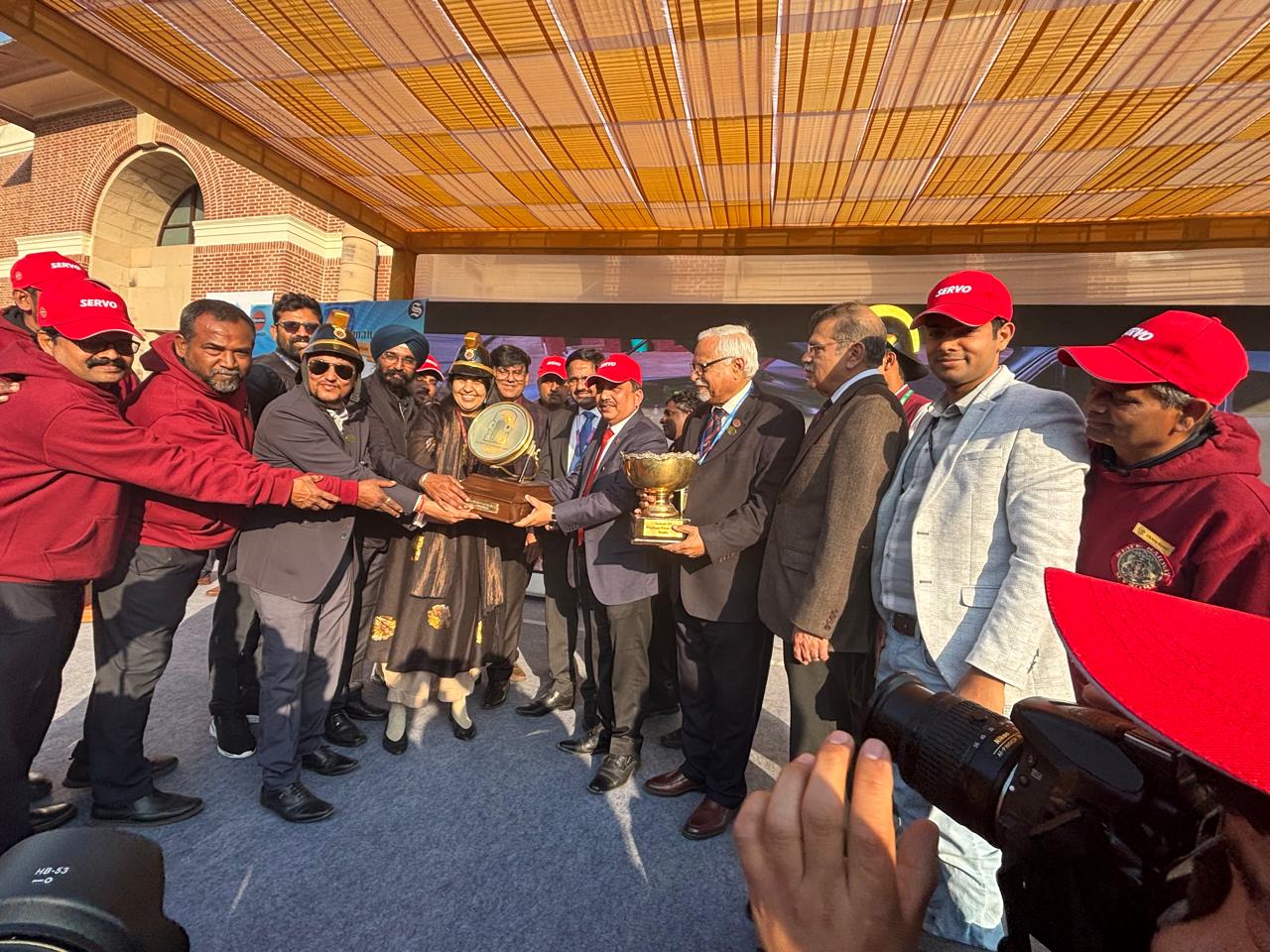 जॉन मॉरिस फायर इंजन रैली में ट्रॉफी के साथ प्रदर्शन करता हुआ